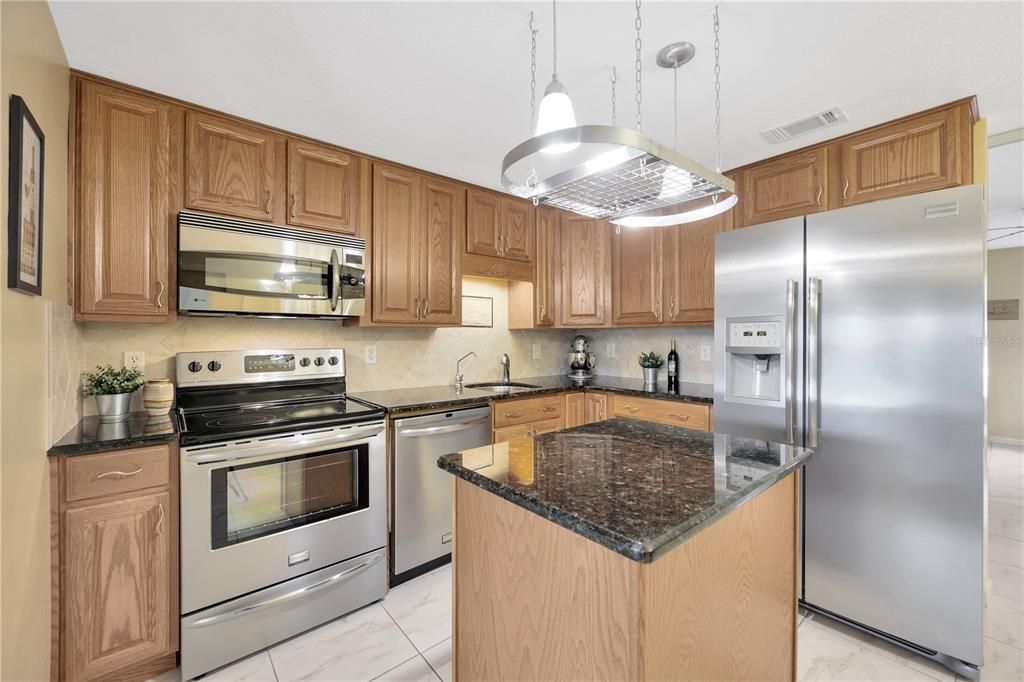 Upgraded Kitchen w/ Hardwood Cabinets, Stainless Steel Appliances, Granite Counters, & Island w/ Storage.