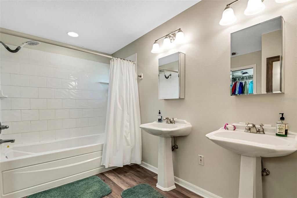 The en-suite bathroom features two pedestal sinks and a 6' deep tub shower . . .  all recently remodeled