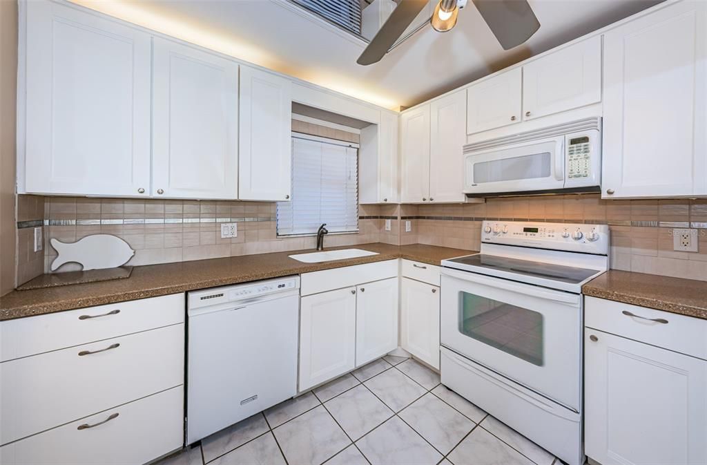 Large Kitchen with wood cabinets, solid surface counters, tiled backsplash & more!