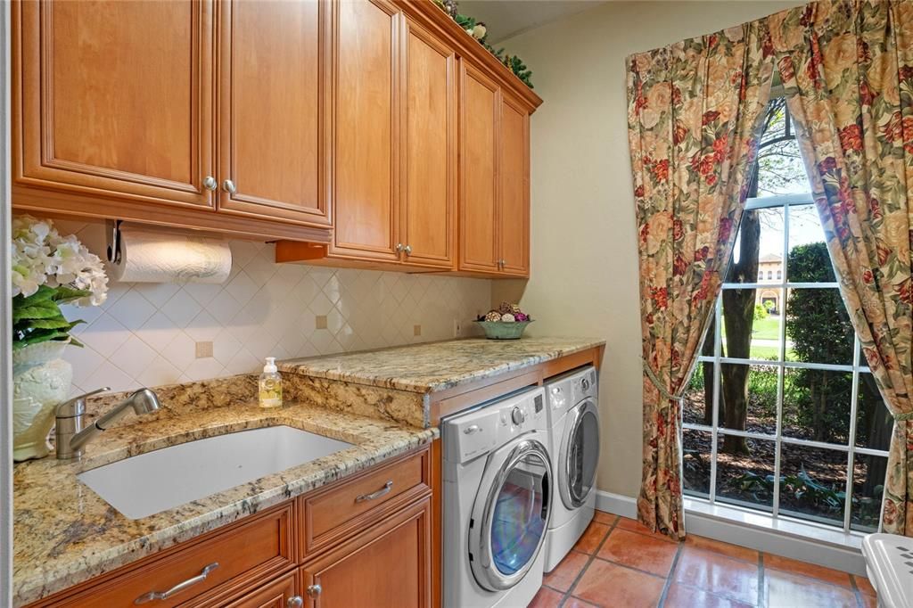 Luxury in Laundry room too!  Granite, custom cabinets, folding space and custom drapes!