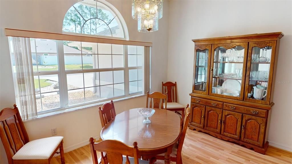 The formal dining room exudes sophistication with its large window that invites ample natural light, complemented by a decorative upper arched transom window. This architectural accent not only enhances the room's spaciousness but also adds an element of refined design, perfect for elegant dinner parties and special family gatherings.