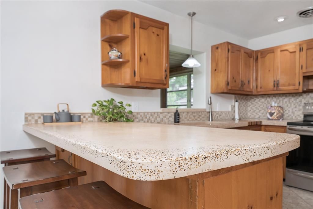 Kitchen with breakfast bar features solid pine cabinets and custom concrete countertops