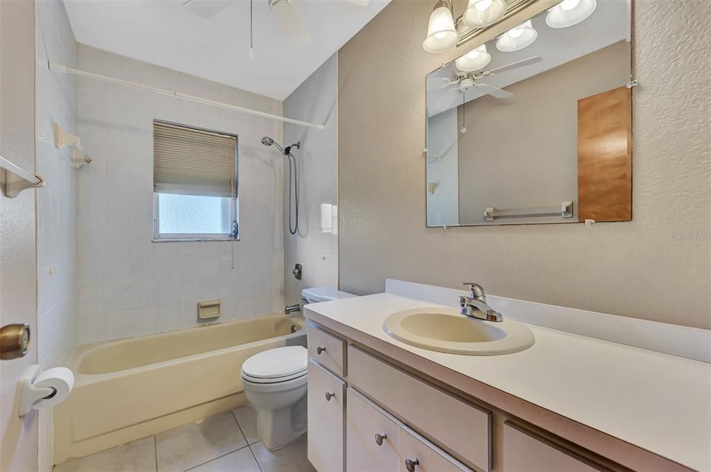 Guest Bath with single vanity and tiled tub/shower surround.