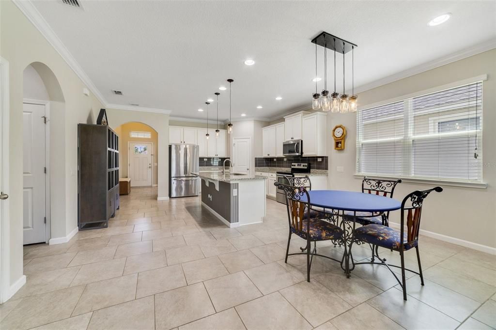 TILE FLOORS throughout the main living areas make maintenance a breeze and add to the open and airy feel of the living room and kitchen complete with space for casual dining and sliding glass doors that access the SCREENED LANAI and backyard!