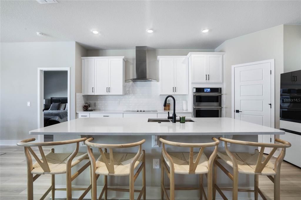 Upgraded and stylish kitchen. Featuring large island. Quartz countertops, Smart micro/oven combo; and dishwasher. Samsung Bespoke glass panels - Extra-large capacity 4-Door French Door Refrigerator