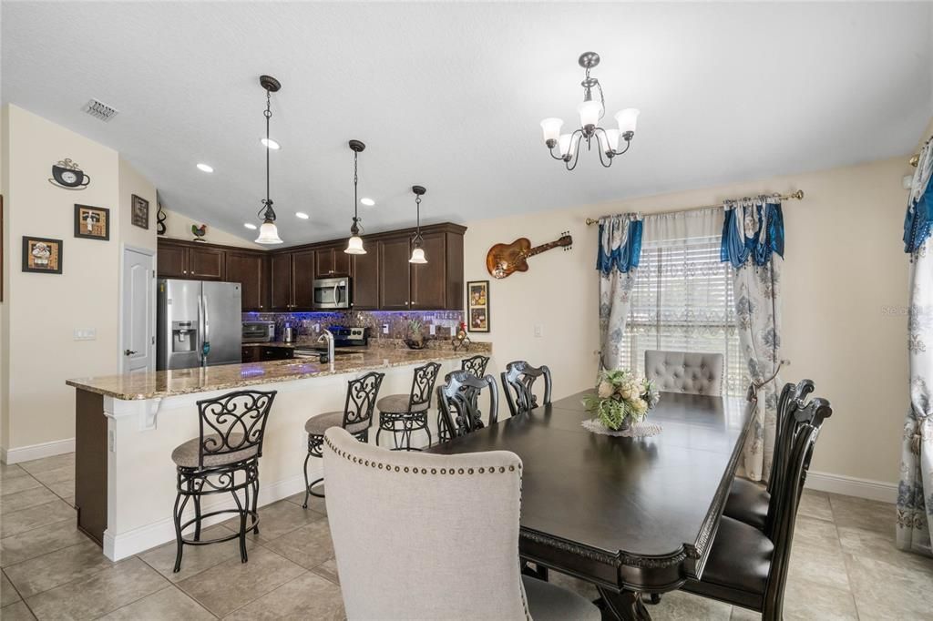 The family chef will appreciate being surrounded by rich solid wood cabinets with under cabinet lighting, STAINLESS STEEL APPLIANCES, pantry for ample storage, GRANITE COUNTERTOPS, a decorative backsplash and breakfast bar seating under pendant lighting perfect for entertaining!