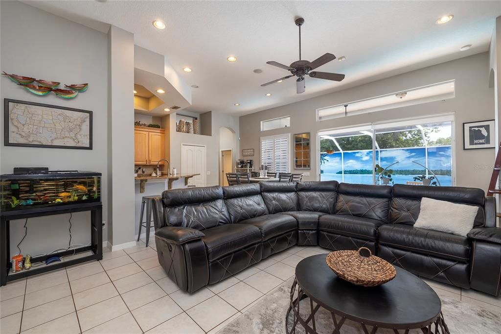 Living room with Kitchen and additional dining space in the background and a view of the pool and lanai