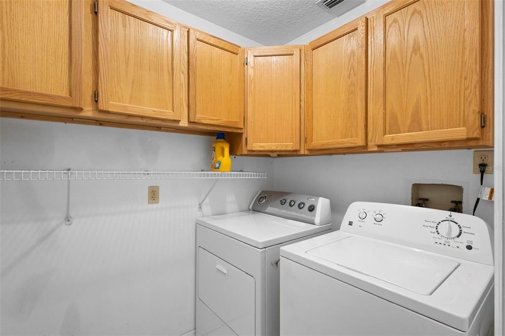 Laundry room located inside with beautiful solid wood cabinets