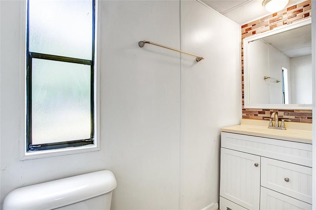 The second bathroom has an entrance both from just beyond the laundry area as well as from the second bedroom. This bathroom includes a single vanity, stand up shower and toilet.