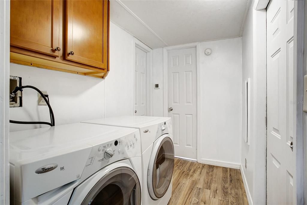 On the back side of the kitchen is the laundry/utility area with a front loading washer and dryer that stay with the home. There is also an exit door going to the back of the property.