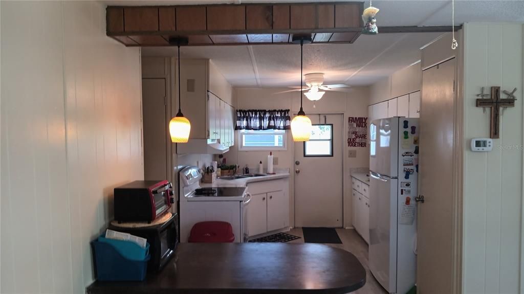 View from dining room into kitchen.  Sellers are leaving the toaster oven, microwave, can opener, and yes, even the Keurig!