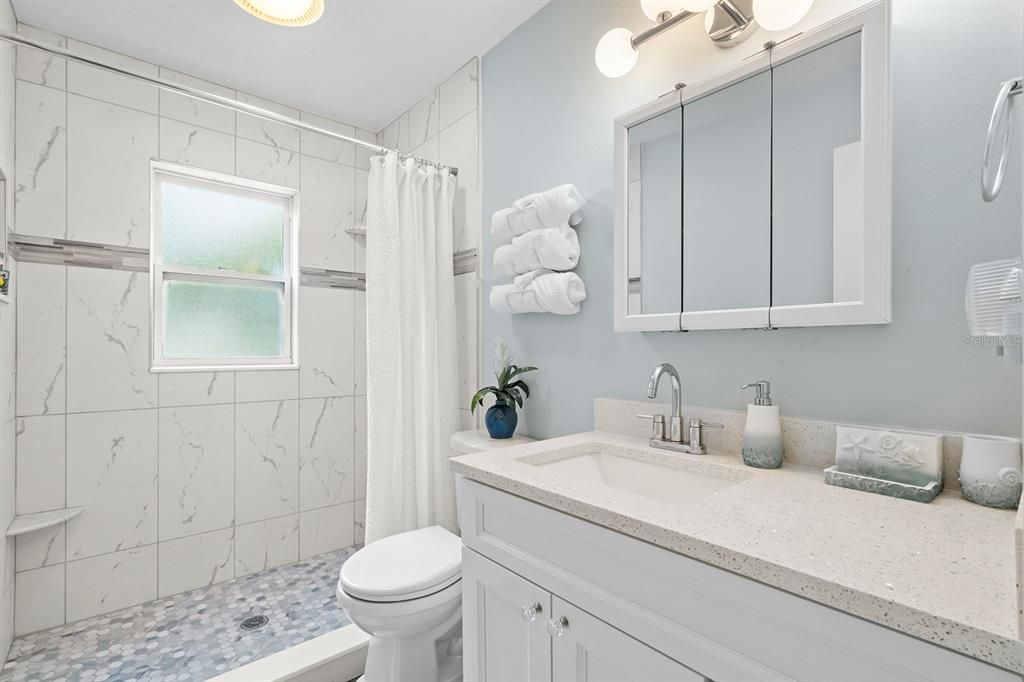 Full Bath in the hallway. Beautifully Updated with quartz countertop and white shaker cabinets.