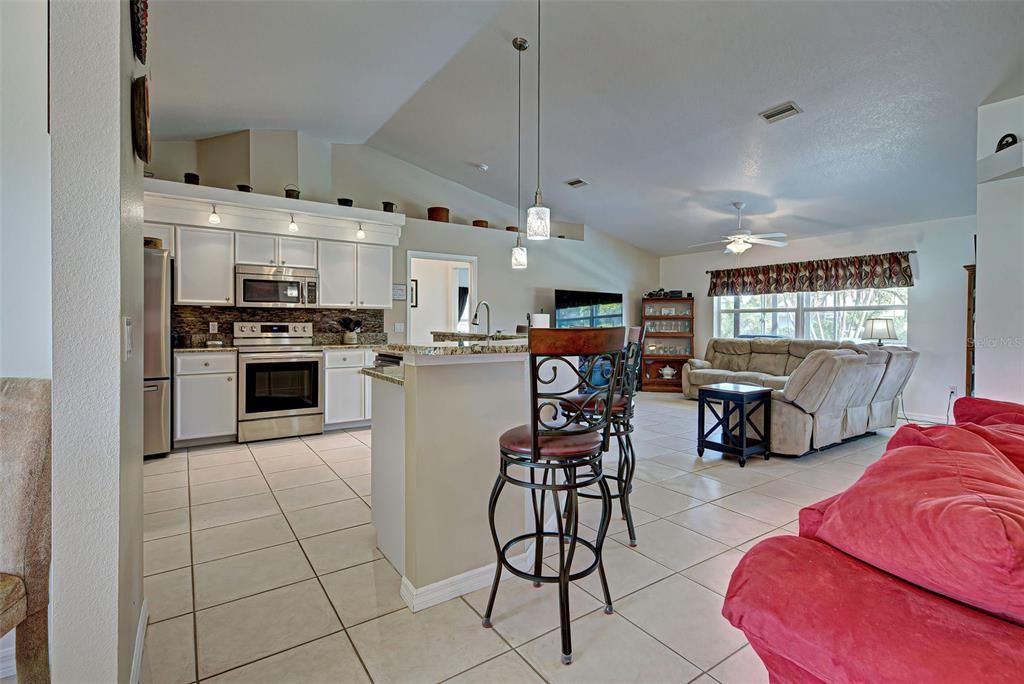 A spacious kitchen with ample cabinets and an island large enough for stools.