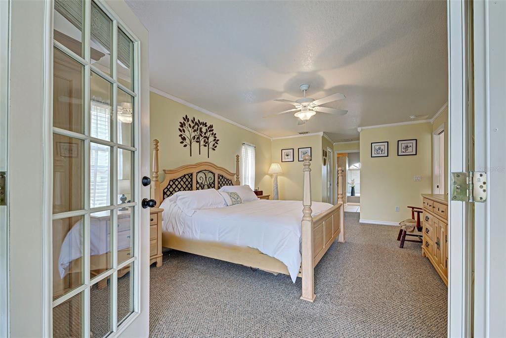 Enter the spacious primary bedroom suite through the french doors off of the lanai.