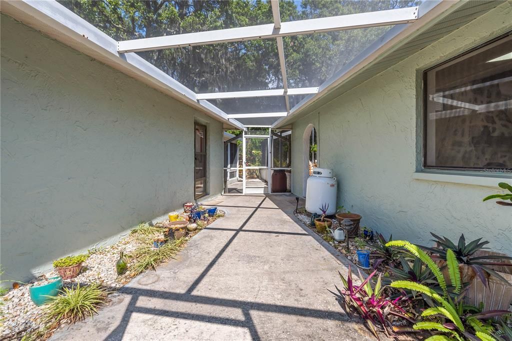 Screened-in breezeway area leading to the detached 2 car garage and studio