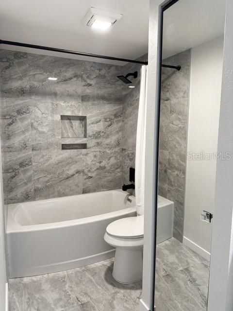 Bathroom next to secondary room- upscale porcelain tile on the floor and walls, new tub with shower