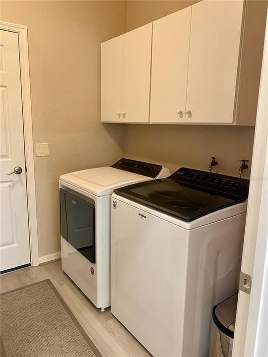 Laundry with newer washer and dryer and cabinets above for storage