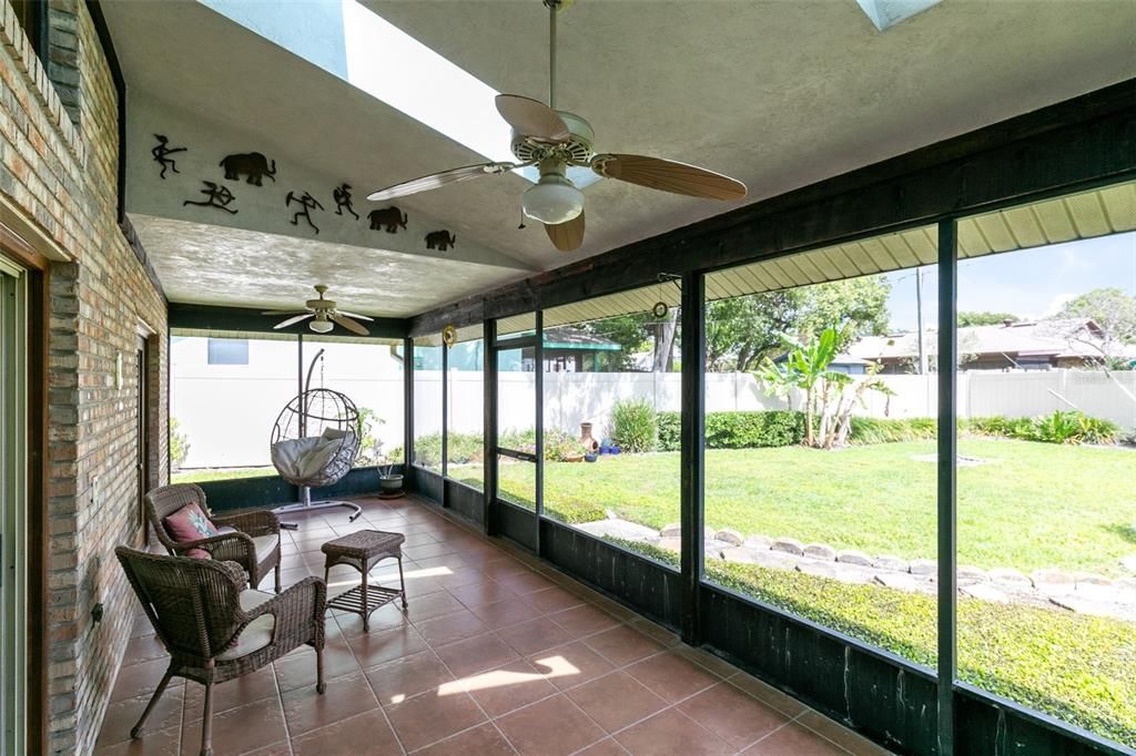 Outside, the screened lanai beckons with its ceiling fans and skylights, overlooking the fully fenced backyard adorned with banana plants and a papaya tree.