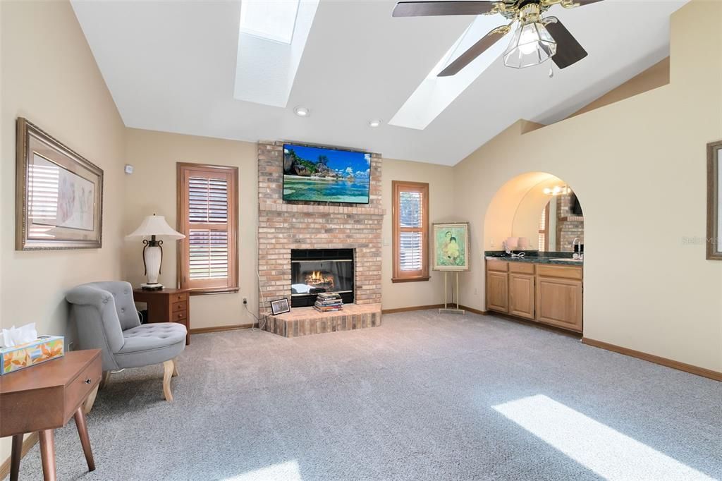 Relax by the wood-burning fireplace, basking in the natural light streaming through skylights overhead.