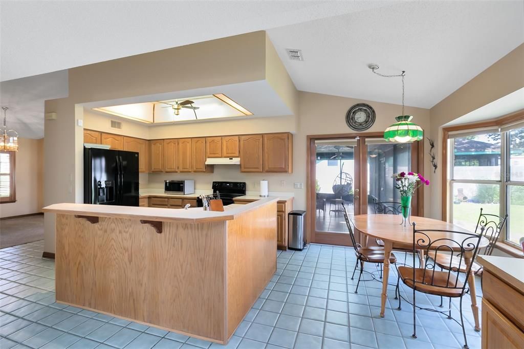 The well-appointed kitchen boasts a convenient breakfast bar, dinette area, and pantry, while French doors lead from the dinette area to the screened lanai, creating a seamless indoor-outdoor flow