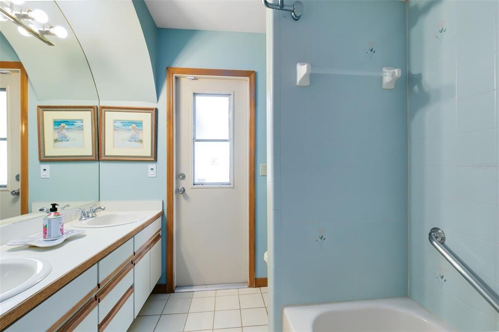 Full bath with dual sinks, tub/shower combo and backyard access.