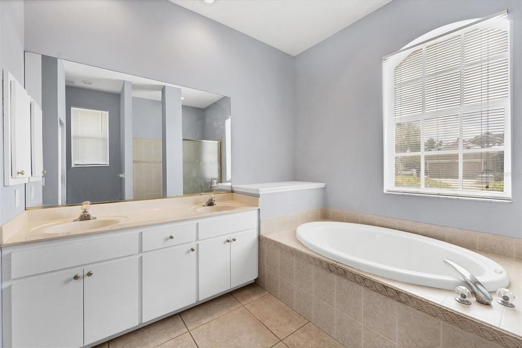 Primary bath with dual sink vanity and separate tub & shower.