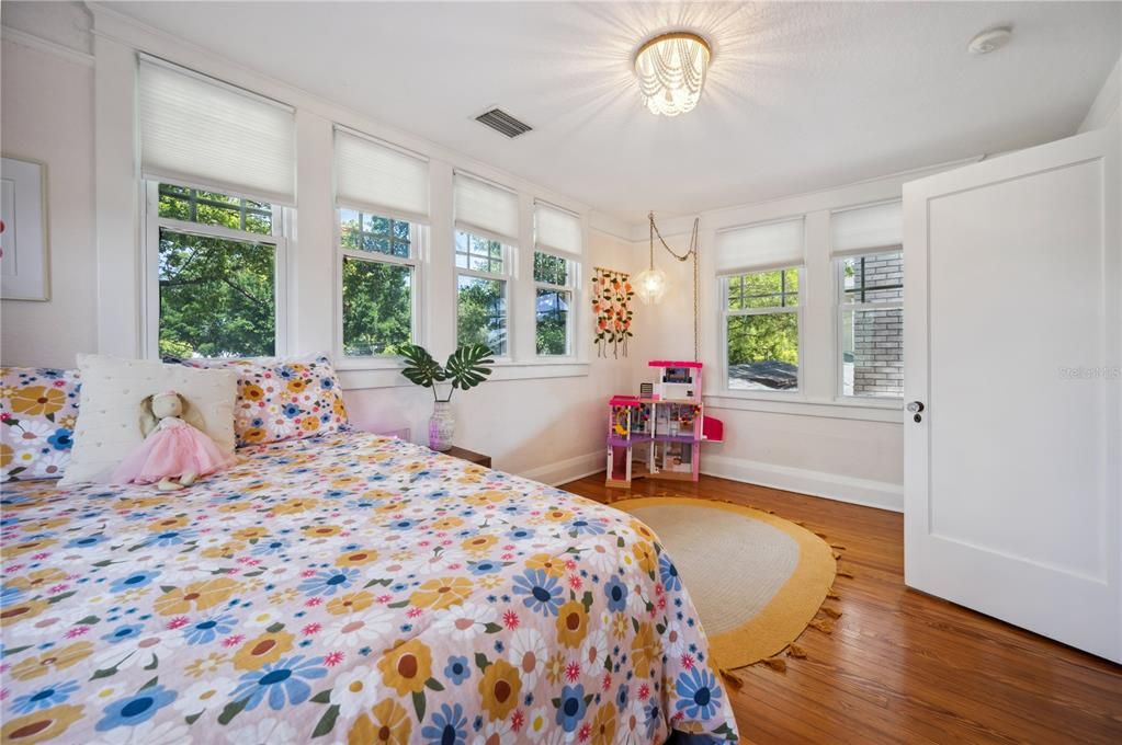 Large bedroom with original hardwood floors and 8 beautiful windows
