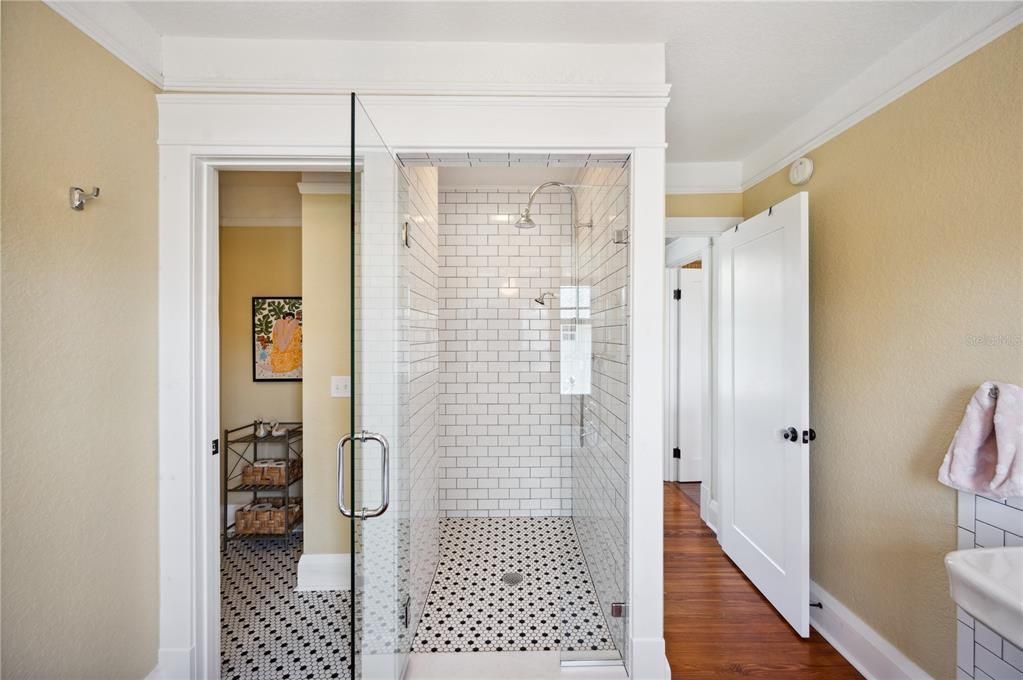 View into private toilet closet, walk-in shower, and main entrance