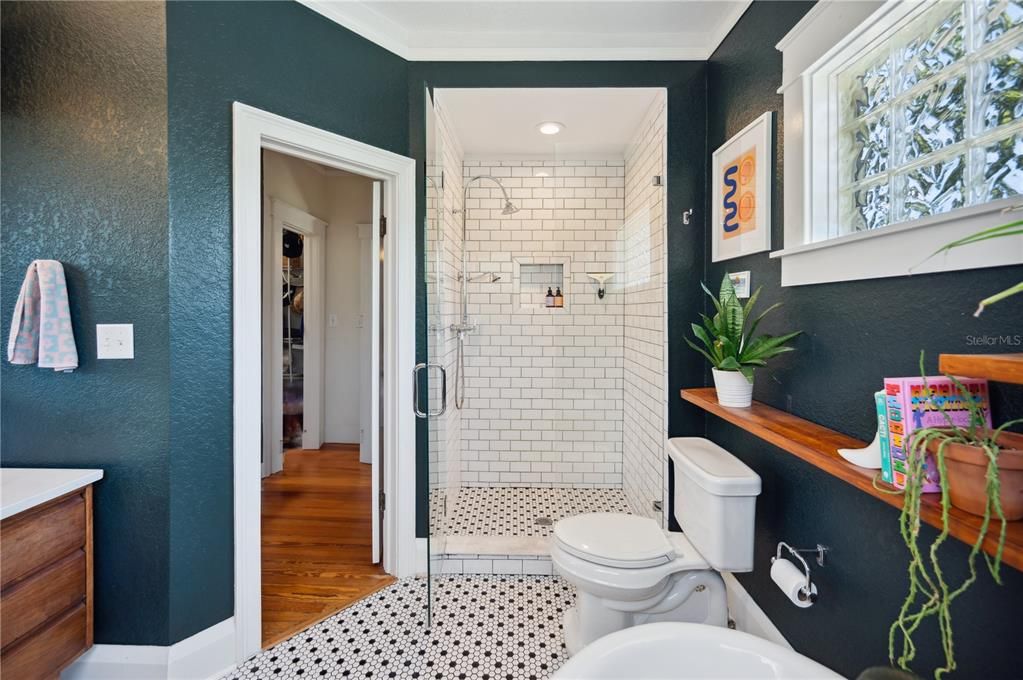 Primary ensuite bathroom with soaking tub, double vanity sinks, and walk-in shower