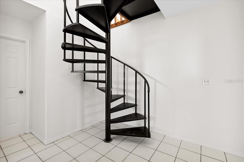 Spiral staircase leading to Primary Bedroom