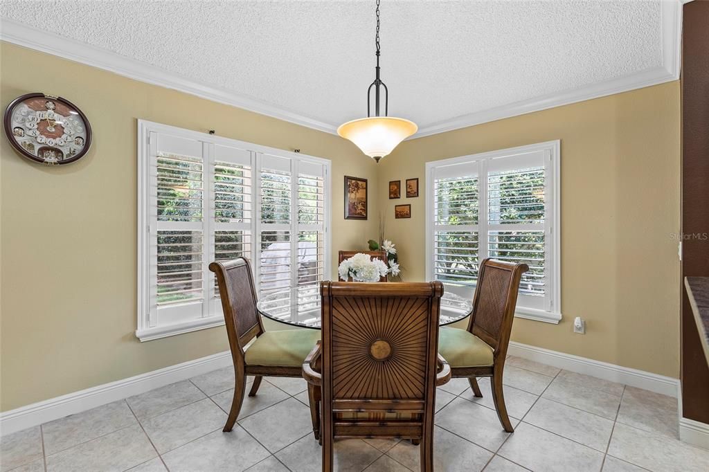 Breakfast nook with crown molding, plantation shutters