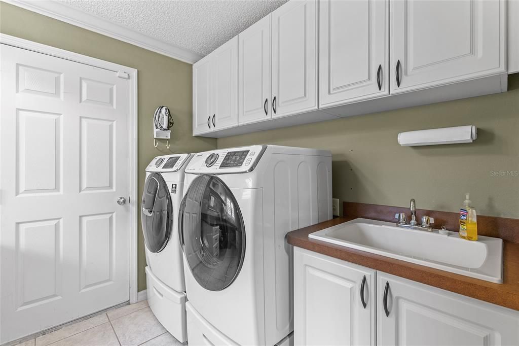 Laundry room with utility sink, cabinets.