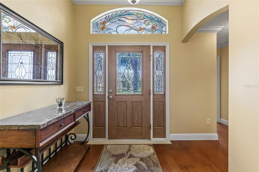 Beautiful Stain glass window in transom above door,  engineered hardwood floos grace the Foyer.