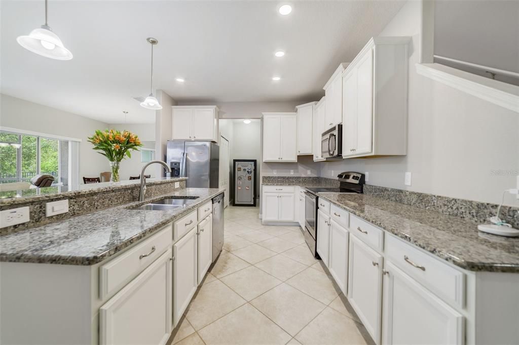 Your foyer opens up to a kitchen designed with the home chef in mind featuring 42” CABINETS topped with crown molding, STAINLESS STEEL APPLIANCES, pantry for ample storage, GRANITE COUNTERS and a breakfast bar off the ISLAND for casual dining or entertaining.