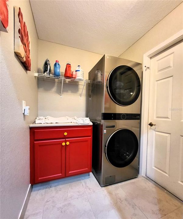 Seller remodeled to add cabinet and stackable LG washer & dryer. Door leads to the garage.