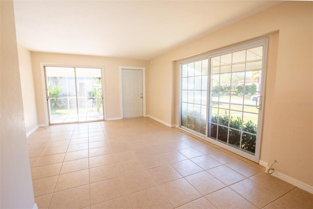 Large family room with front door and sliding door to the screened lanai.