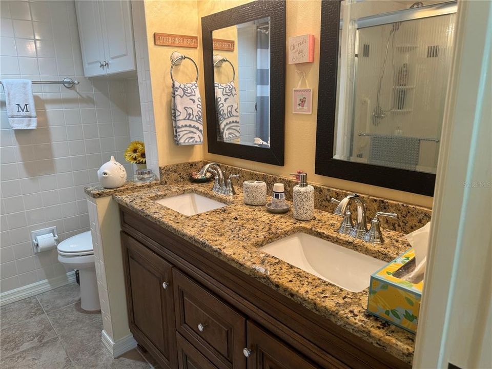primary bath with double sinks and granite counter