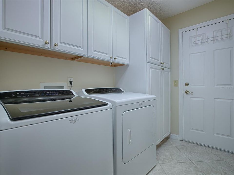 LAUNDRY ROOM WITH WASHER AND DRYER THAT DO CONVEY, EXTRA CABINETS AND PANTRY FOR STORAGE. THIS DOOR LEADS TO THE GARAGE.