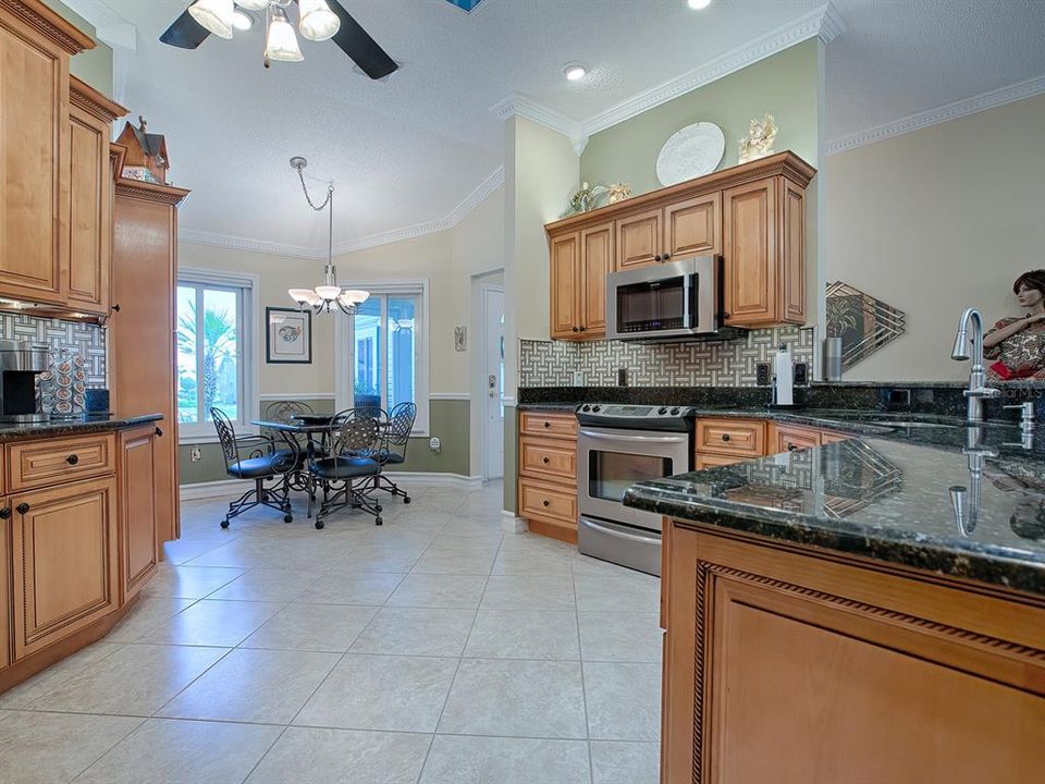 THE SPACIOUS KITCHEN HAS CROWN MOLDING WITH LOVELY CHERRY CABINETS WITH OVER AND UNDER CABINET LIGHTING, UPPER AND LOWER PULL OUT DRAWERS IN LOWER CABINETS AND SOFT CLOSE DRAWERS.