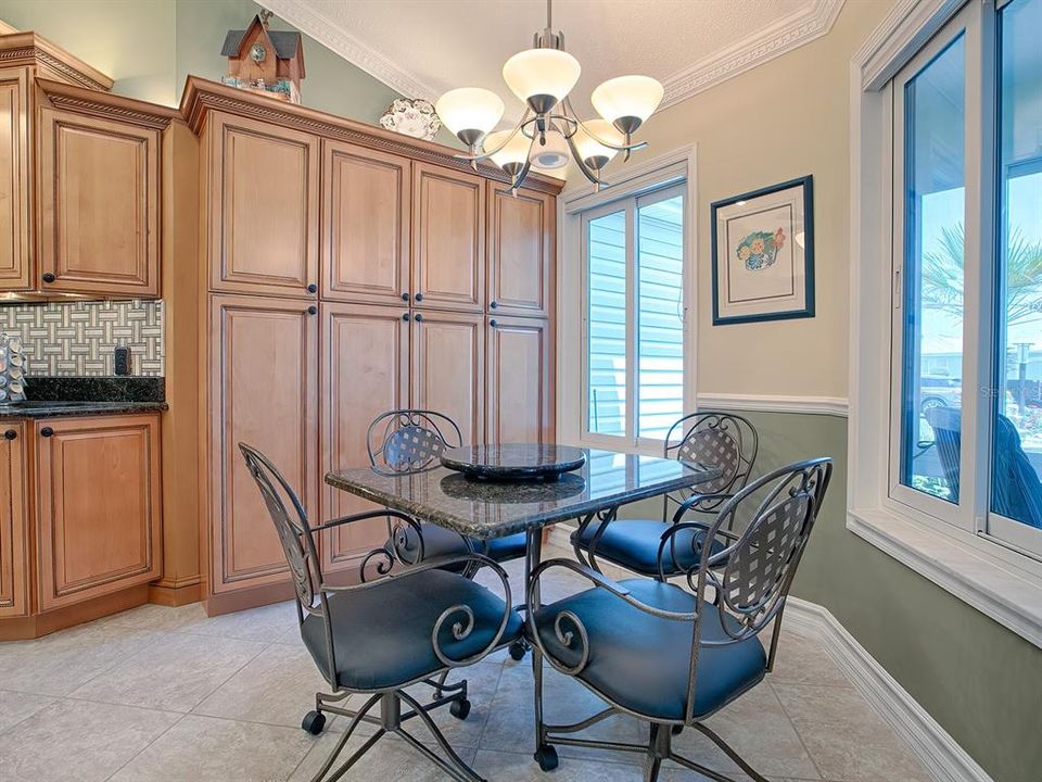 FROM THE FOYER, STEP INTO THE CASUAL DINING AREA WITH CUSTOM CABINETS AND PANTRY.  UPGRADED WINDOWS THROUGHOUT THE HOME!