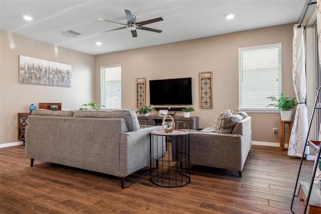 Your open concept living room has overhead lighting, tons of natural light, and glass sliders to the screened in lanai.