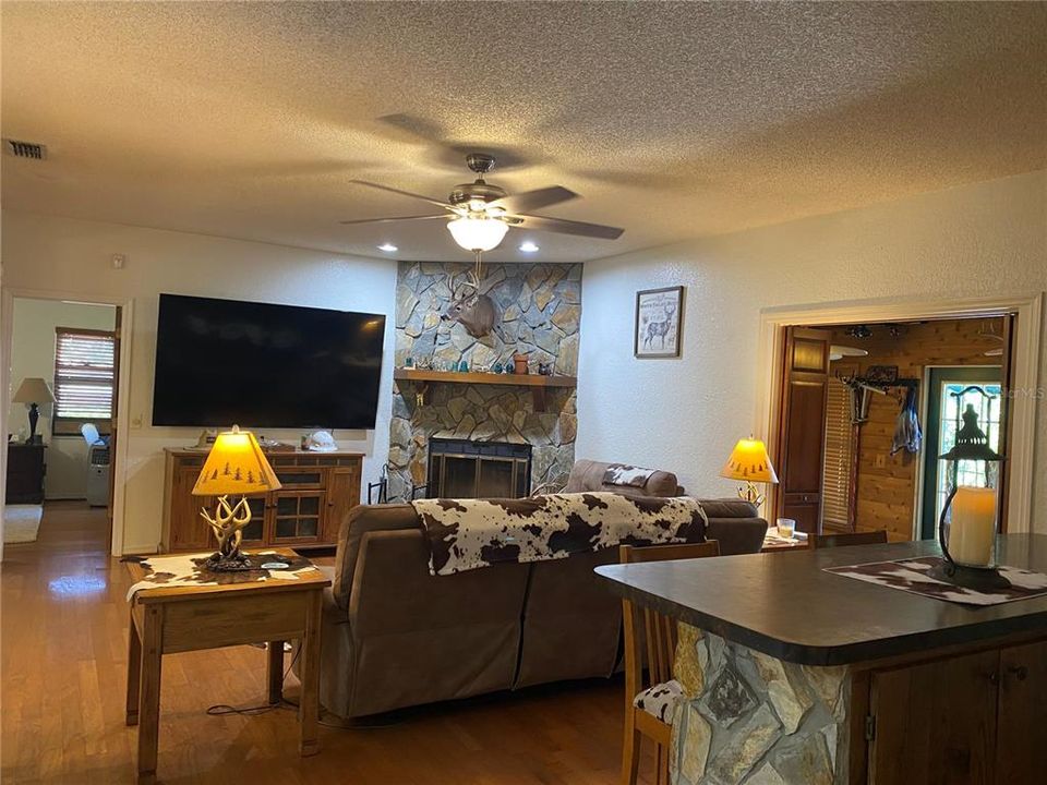 The wood burning fireplace fills the back corner of the living room.  Wood flooring throughout the living room, dining area, dinette area and master bedroom.