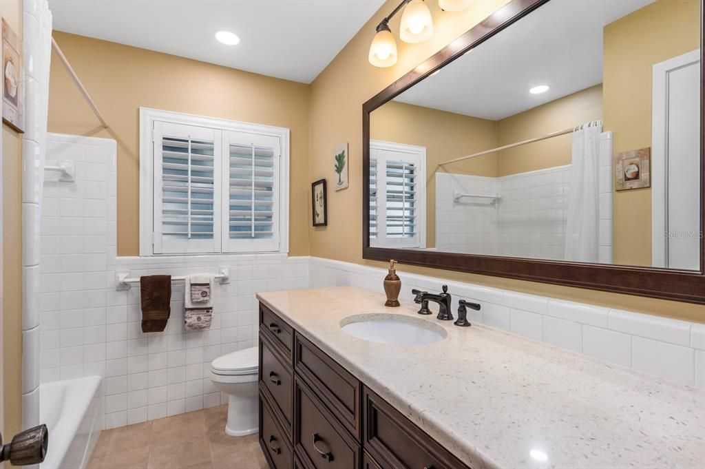 Guest Bathroom - new soft touch close cabinetry with quartz counters, commode and flooring