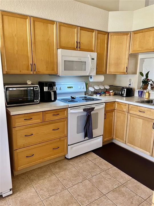 Kitchen with all new appliances, and tiled flooring.