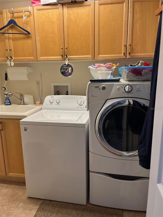Laundry room right inside entry and close to garage.  Utility sink, plenty of overhead cabinets, and another pull down attic access for storage.
