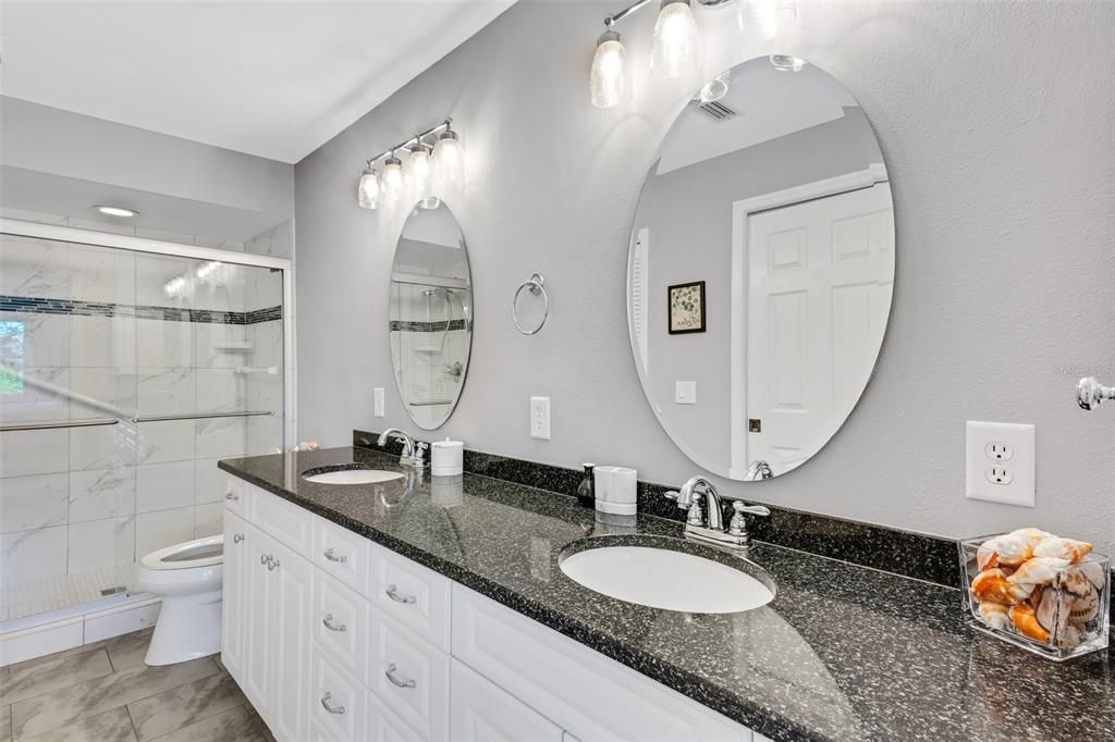 Updated Master Bathroom featuring dual sinks, Granite, & walk-in shower.