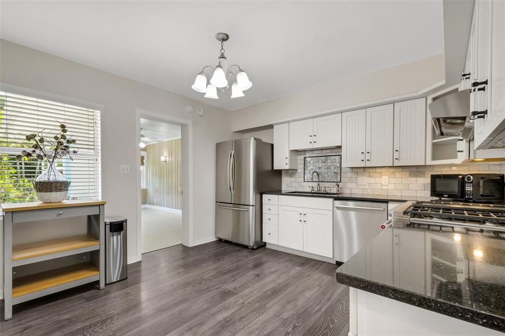 the kitchen features a wonderful inside laundry, pantry, gas cooking and stainless appliances. This view also leads you into the sunroom/bonus living space. This room is flooded with natural and has great views of the private backyard oasis.