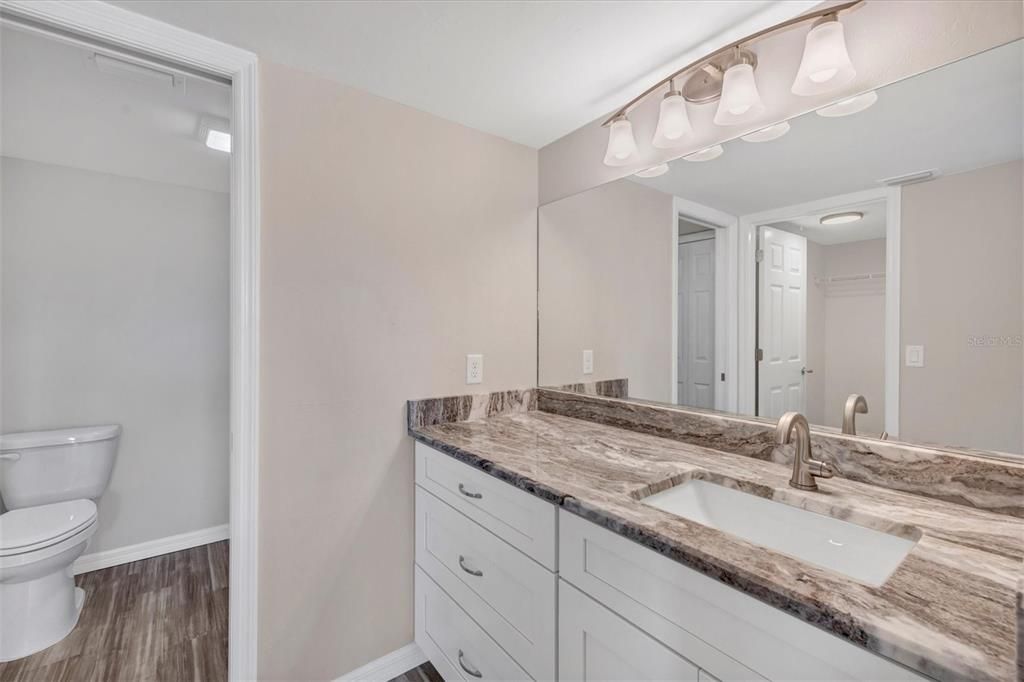 Primary Bathroom - wood cabinets, granite, tile