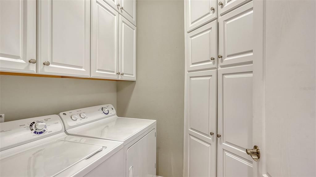 Utility room has corner cabinets and double cabinets over the washer and dryer, great storage.