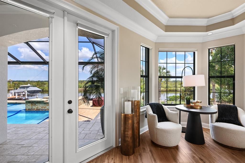 Primary bedroom with sitting area overlooking pool